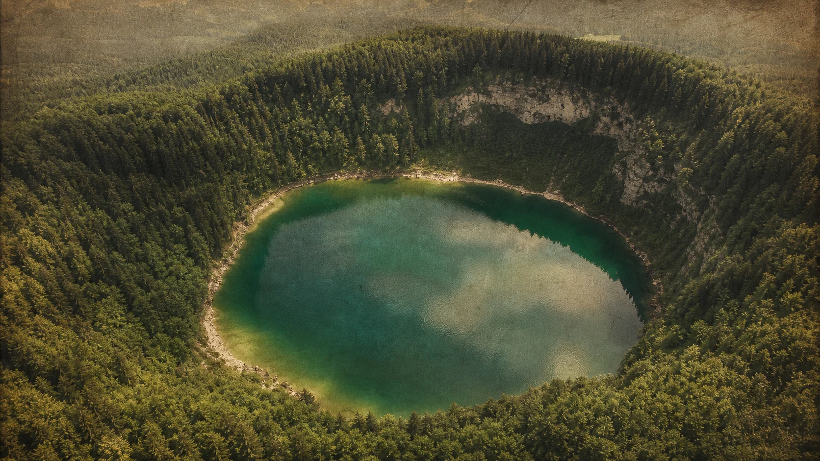 Vedere aeriană a unui lac de crater — forma geologică care invită lectură simbolică